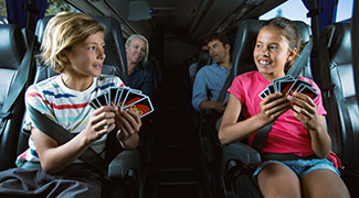 Children having fun playing card games on a bus