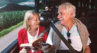 A mature-aged couple on holiday and travelling on a coach
