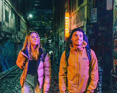 Couple at night in Melbourne graffiti alley.