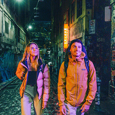 Couple at night in Melbourne graffiti alley.