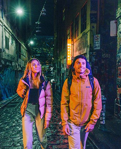 Couple at night in Melbourne graffiti alley.