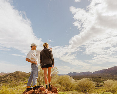Couple on top of a rock column in the outback.
