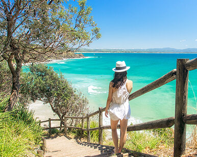 Photo of a young lady descending beach stairs.