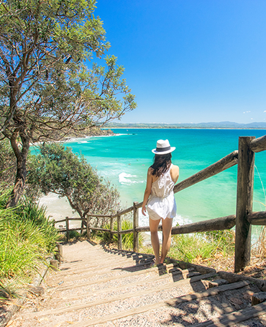Photo of a young lady descending beach stairs.